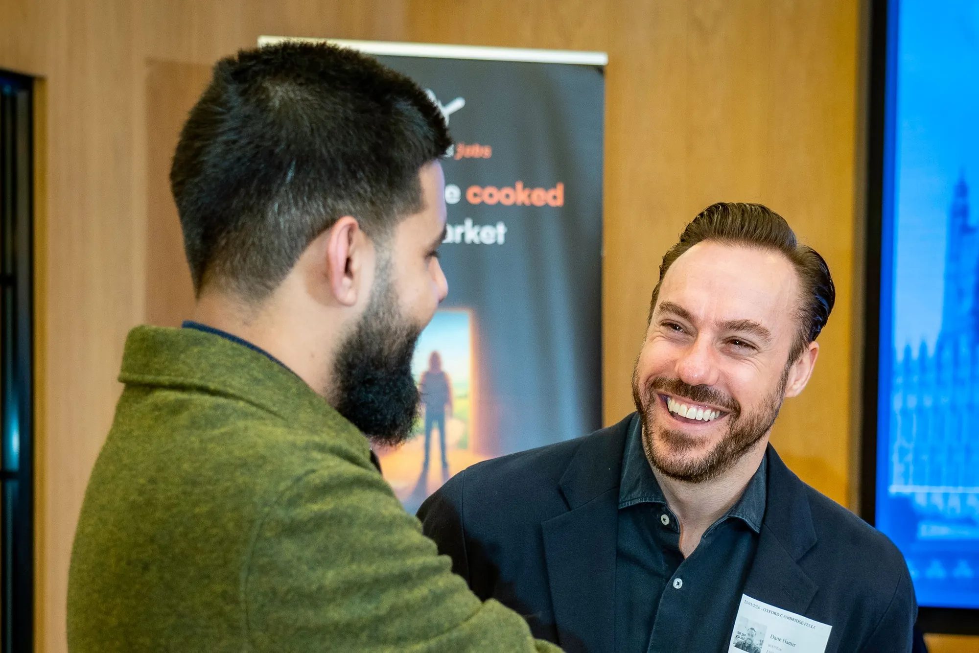Two guests laughing together at the mixer.