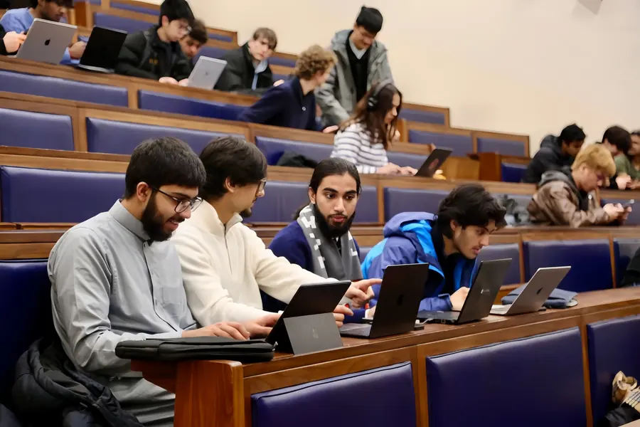 Builders at laptops in a lecture theatre.