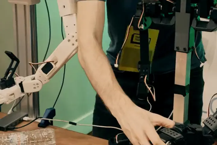 Hands on the arm of a humanoid robot, then its head up close.